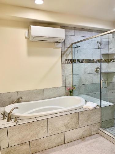 a bathroom with a tub and a glass shower at Annie's Place Bed & Breakfast in Boulder Town