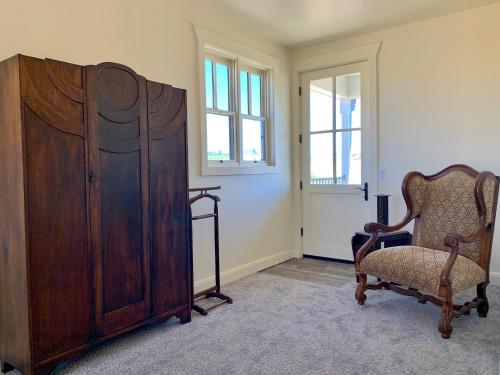 a room with a chair and a large wooden cabinet at Annie's Place Bed & Breakfast in Boulder Town
