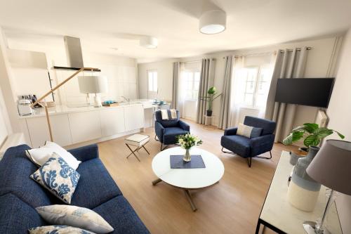 a living room with a blue couch and chairs at Le Rempart du Midi in Angoulême