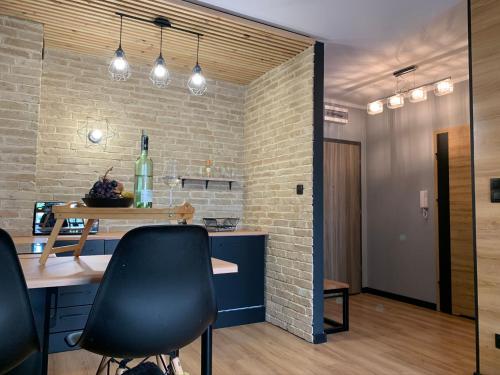 a kitchen with a table and chairs and a brick wall at Tarnovia Loft Apartment in Tarnowo Podgórne