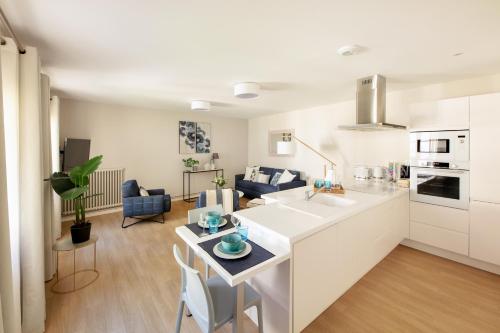 a kitchen and living room with a table and a counter top at Le Rempart du Midi in Angoulême