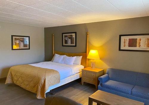 1 dormitorio con 1 cama y 1 sofá azul en Hotel Veranda DuBois en DuBois