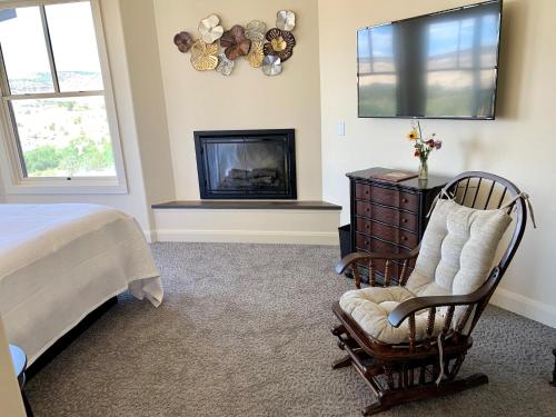 a bedroom with a bed and a chair and a fireplace at Annie's Place Bed & Breakfast in Boulder Town