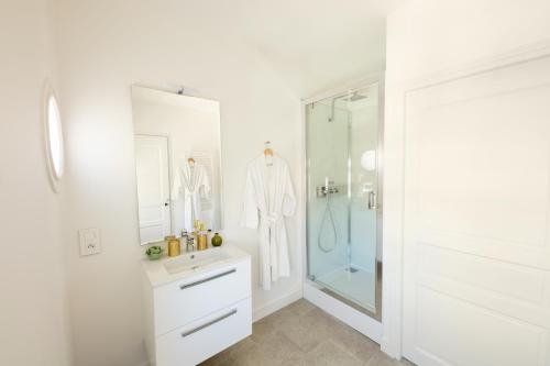 a white bathroom with a shower and a sink at Le Rempart du Midi in Angoulême