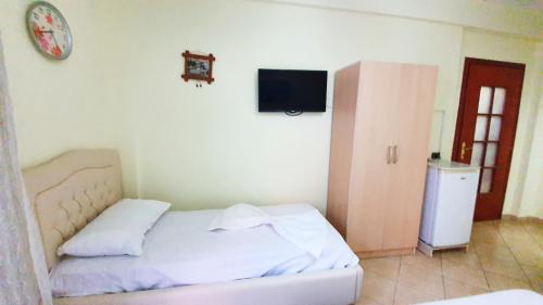 a bedroom with a bed and a tv on the wall at Vila Vera in Durrës