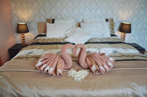 two towel swans sitting on top of a bed at amel orawa in Podwilk