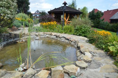 a pond in a garden with a stone wall at amel orawa in Podwilk