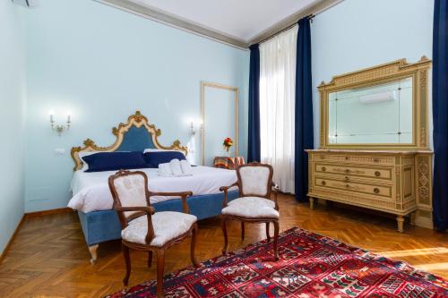 een slaapkamer met een bed, 2 stoelen en een dressoir bij Casa della Contessa B&B in Turijn