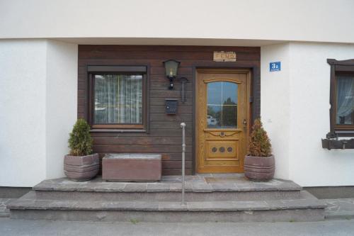 a house with a wooden door and two potted plants at FEWO Außerlechner in Innsbruck