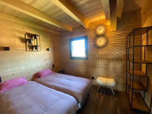 a room with two beds and a window in it at L'ADRET DU TEMPS CHALET 10 PERSONNES 170m2 in Gérardmer