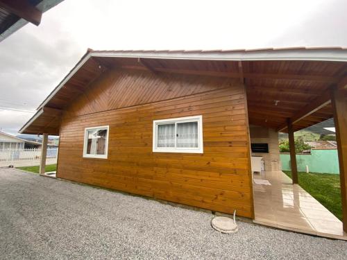 un gran edificio de madera con 2 ventanas. en Casas de Hospedagem Mendes, en Urubici