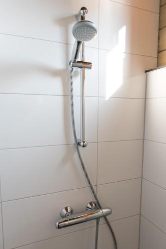 a shower with a shower head in a bathroom at Vakantiehuis De Schaapskooi in Drunen
