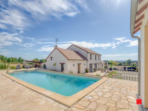 a villa with a swimming pool and a house at maison blanche piscine et petit déjeuner in Châtellerault