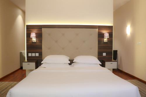 a bedroom with two beds with white sheets and a headboard at Royal Golden House in Dammam
