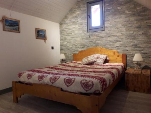 1 dormitorio con cama y pared de ladrillo en Chalet Lucie LE CHEVAL NOIR en Valmorel