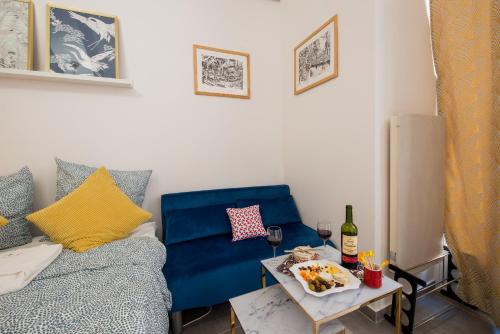 un salon avec un canapé bleu et une table dans l'établissement Studio - Moderne - Netflix & Wifi, à Paris