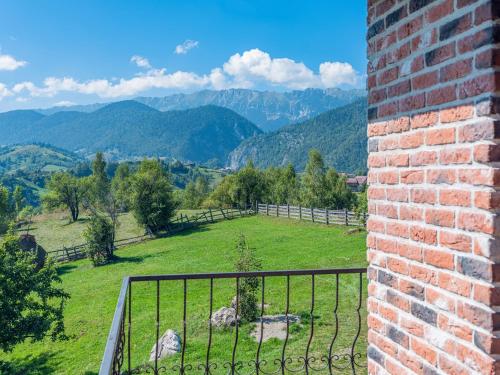 a room with a view of a field and mountains at Casa de Cărămidă in Moieciu de Jos