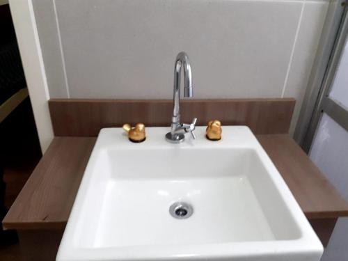 a white sink with a faucet in a bathroom at Apto Sao Vicente in São Vicente