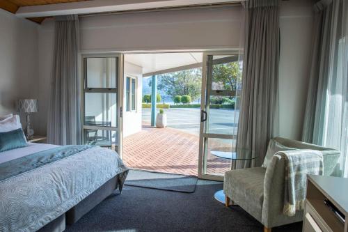 a bedroom with a bed and a sliding glass door at Radfords on the Lake in Te Anau
