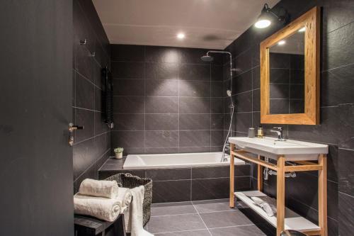 a bathroom with a sink and a tub and a mirror at Luxury Alpine Residence with Hot Tub - By Ski Chalet Andorra in Soldeu