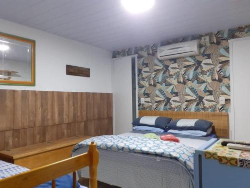 um quarto com duas camas individuais e uma parede com avertisement em Pousada Quintal Verde Floripa em Florianópolis