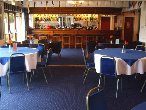 a restaurant with tables and chairs and a bar at Riverside House in Hamble