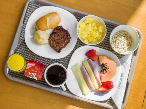 a tray with plates of food on a table at ibis Jaboticabal in Jaboticabal