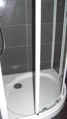 a shower with a glass door on top of a shower at Hotel Du Port in Concarneau