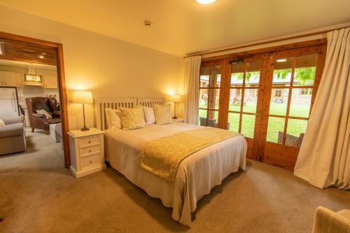 a bedroom with a bed and a large window at Wanaka Homestead Lodge & Cottages in Wanaka