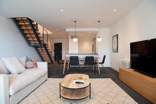 a living room with a couch and a table at Loft at Shed 5 - Ahuriri Holiday Apartment in Napier