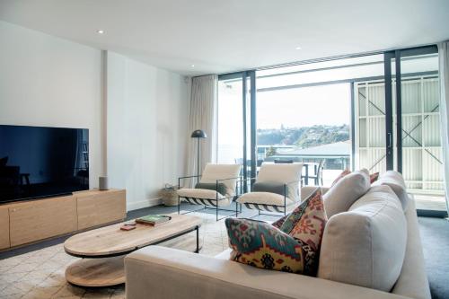 a living room with a couch and a tv at Loft at Shed 5 - Ahuriri Holiday Apartment in Napier