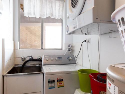 a kitchen with a sink and a washing machine at Kiah 8 stunning water views WI FI and Air Con in Nelson Bay