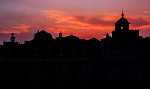a silhouette of a city with a sunset in the background at Ostello degli Elefanti in Catania