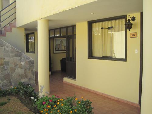 a hallway of a house with a pillar and flowers at La Posada del Conde Lodge in Cabanaconde