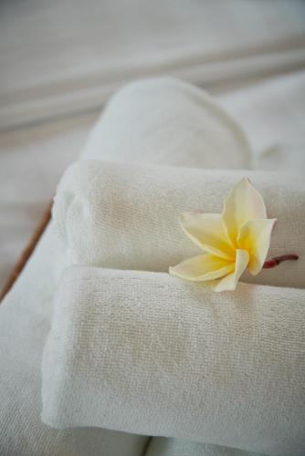 a white flower sitting on top of white towels at Gala Villa Pattaya in Pattaya South