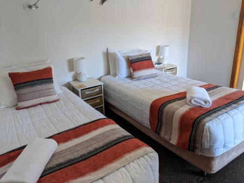 a bedroom with two beds with towels on them at Karuah Motor Inn in Karuah