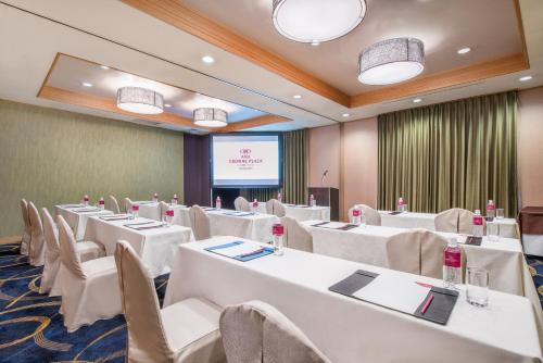 a conference room with white tables and chairs and a screen at ANA Crowne Plaza Kanazawa by IHG in Kanazawa