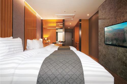 a hotel room with two beds and a flat screen tv at Jeongseon Intoraon Hotel in Jeongseon