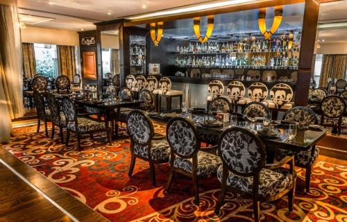 a dining room with tables and chairs and a bar at Sofitel Mumbai BKC in Mumbai