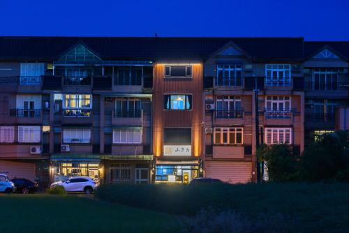 a large apartment building with lights in front of it at 山多香青年民宿 Santhosham Hostel in Sanxing