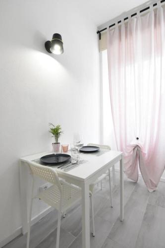 a white table and chairs with plates and glasses at La Casa di Oreno in Vimercate