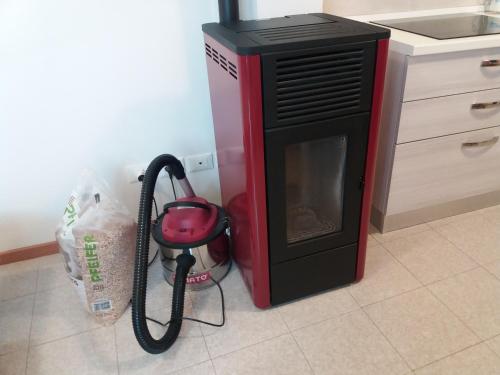 a microwave oven with a hose next to a stove at Appartamento Cillà in Comano Terme