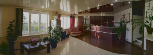 a lobby with potted plants in a building at Vega Hotel in Irkutsk