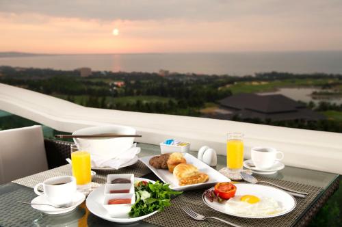 a breakfast table with eggs and food on a balcony at Sea Links Beach Hotel in Mui Ne