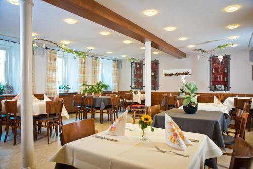 ein Esszimmer mit weißen Tischen, Stühlen und einem Tischler in der Unterkunft Gasthaus Löwen in Tuttlingen