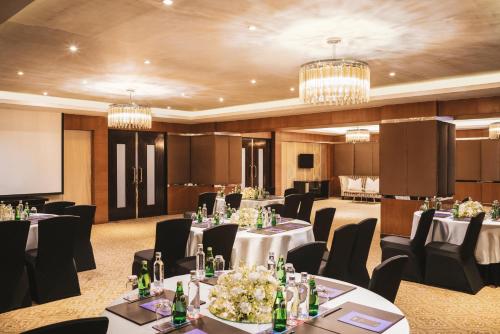 a conference room with tables and chairs and a screen at Sofitel Mumbai BKC in Mumbai