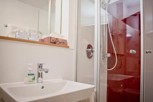 a bathroom with a sink and a shower at Gasthaus Löwen in Tuttlingen