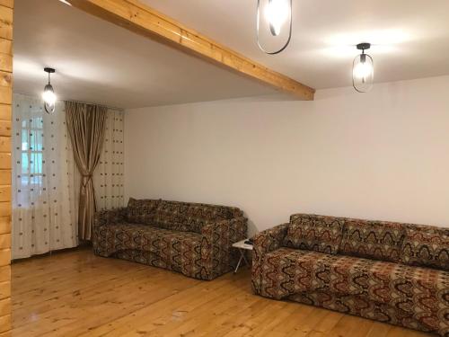 a living room with two couches and a couch at Căsuțele Doftanei in Teşila