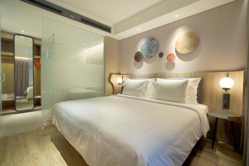 a bedroom with a large bed and planets on the wall at Harris Suites Puri Mansion in Jakarta