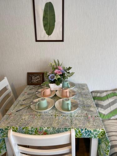 a dining room table with plates and vases on it at Takemura Building 303 in Tokyo